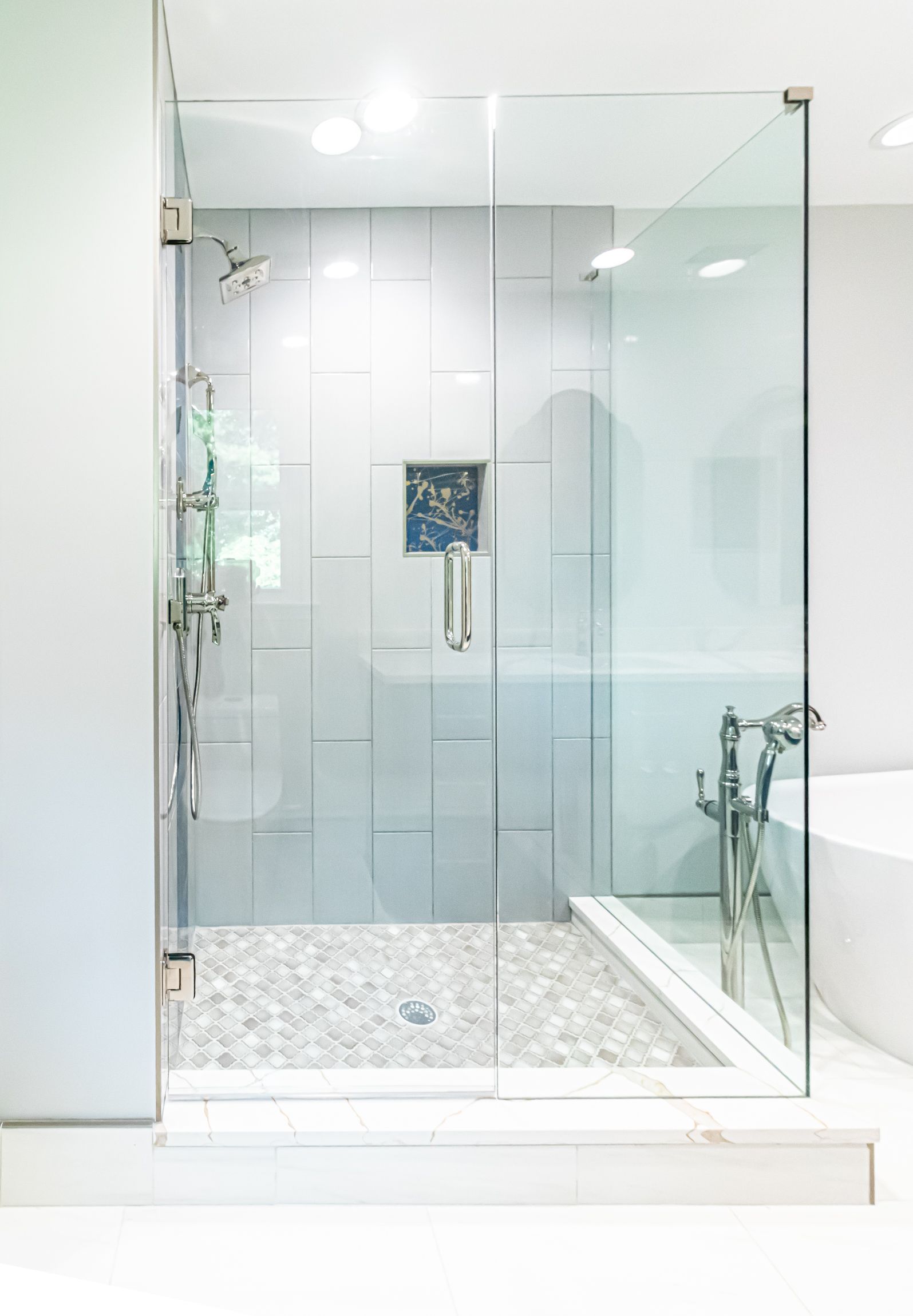 Modern bathroom with a glass-enclosed shower and white tile floor