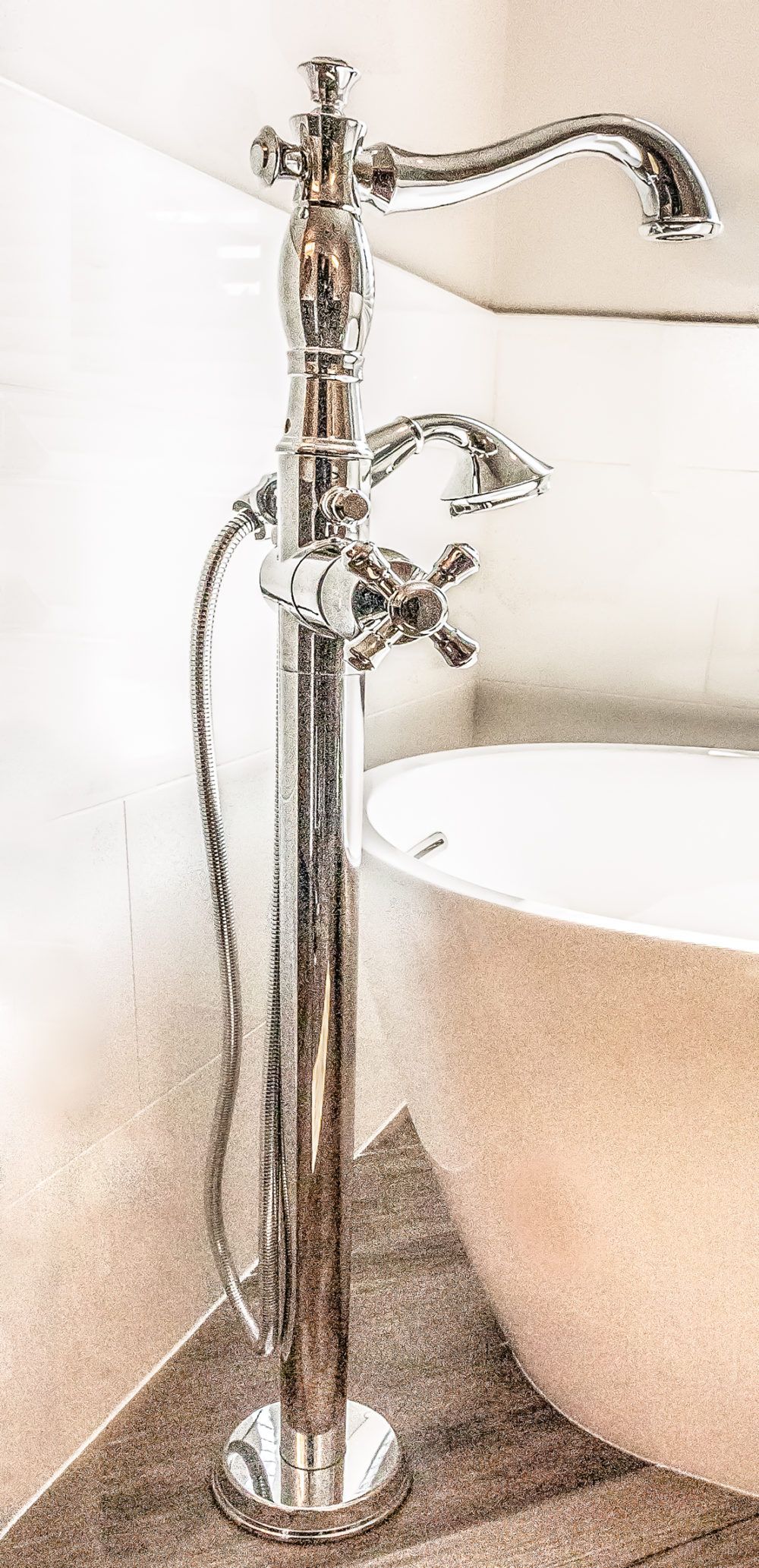 Chrome floor faucet next to a sink with water spraying from the spout