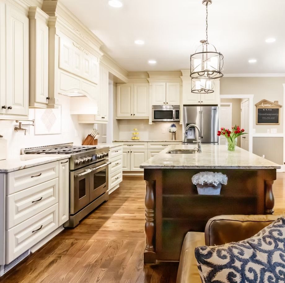 Bright modern kitchen with white cabinets, stainless appliances, granite island, and wood floors