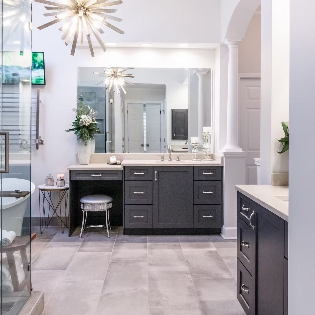 Bright modern bathroom with double vanity, large mirror, gray cabinets, and white tiled floor