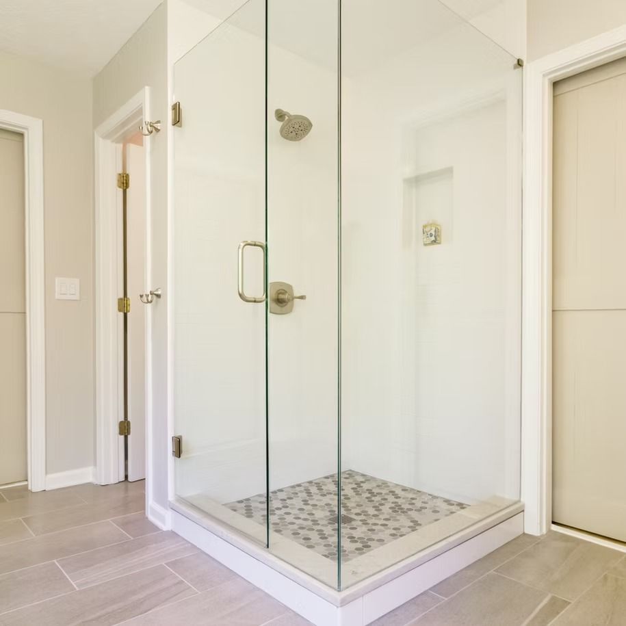 Glass-enclosed shower with tiled floor in a bright, modern bathroom