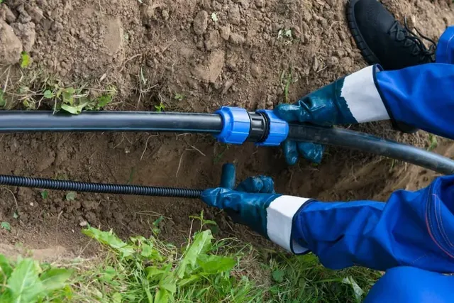 A Person is Installing a Drip Irrigation System in the Ground — Edwards Plumbing Pty Ltd in Tweed Heads, NSW