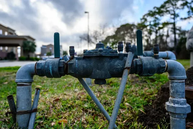 A Water Meter is Sitting in the Grass in Front of a House — Edwards Plumbing Pty Ltd in Burringbar, NSW