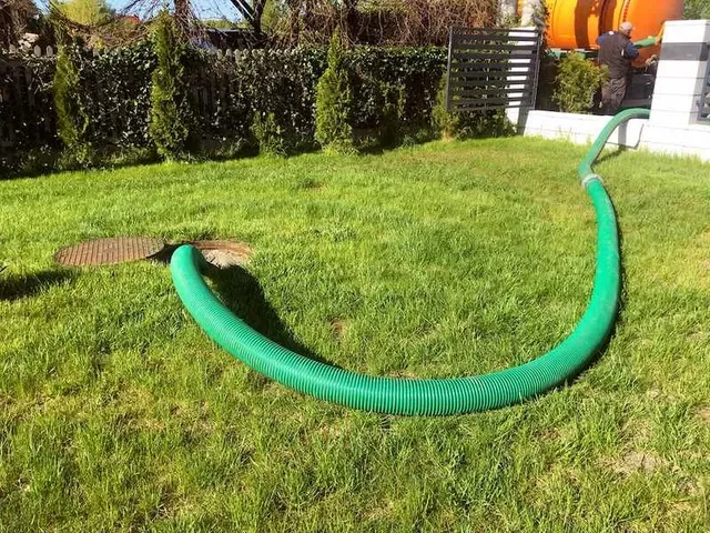 A Green Hose is Sitting on Top of a Lush Green Lawn — Edwards Plumbing Pty Ltd in Kingscliff, NSW