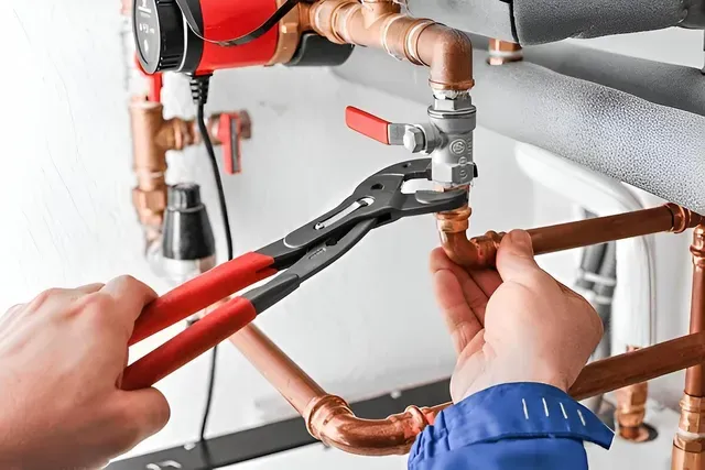 A Plumber is Fixing a Pipe With a Pair of Pliers — Edwards Plumbing Pty Ltd in South Murwillumbah, NSW