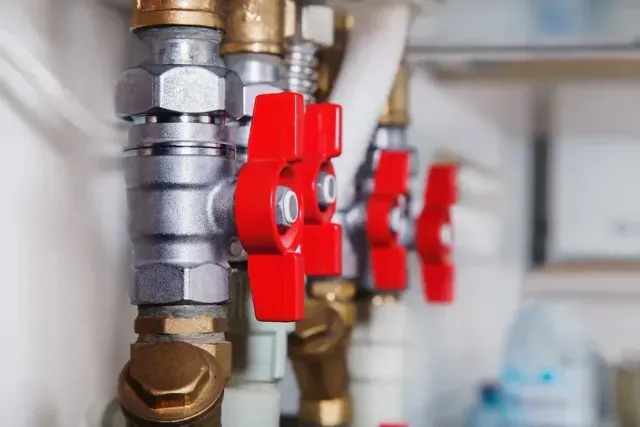 A Row of Water Pipes With Red Valves on Them — Edwards Plumbing Pty Ltd in Tweed Heads, NSW
