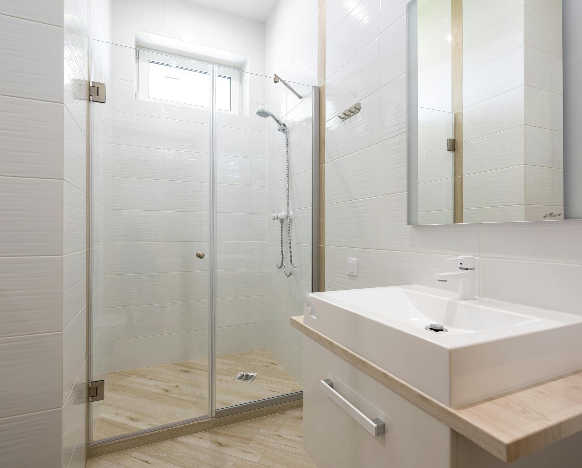 A Bathroom With a Sink, Mirror and Walk in Shower — Edwards Plumbing Pty Ltd in Uki, NSW
