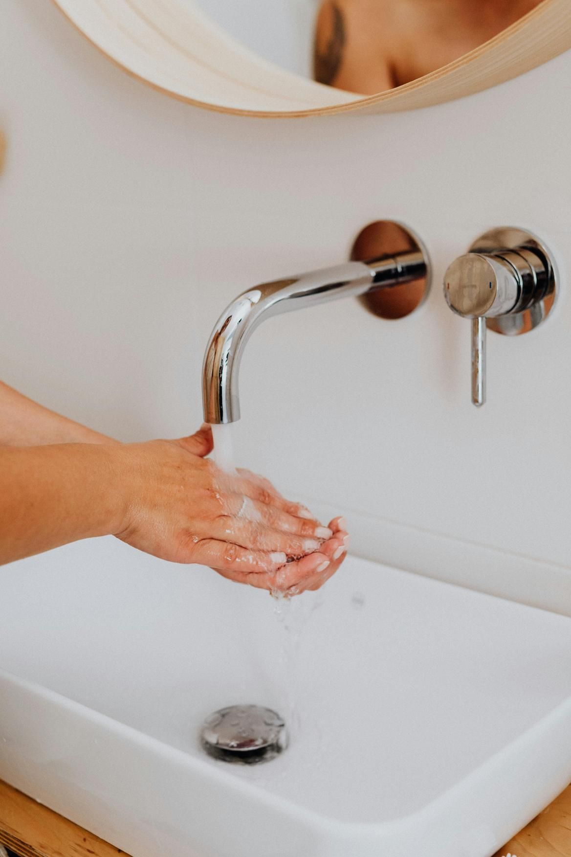 A Person is Washing Their Hands in a Bathroom Sink — Edwards Plumbing Pty Ltd in South Murwillumbah, NSW