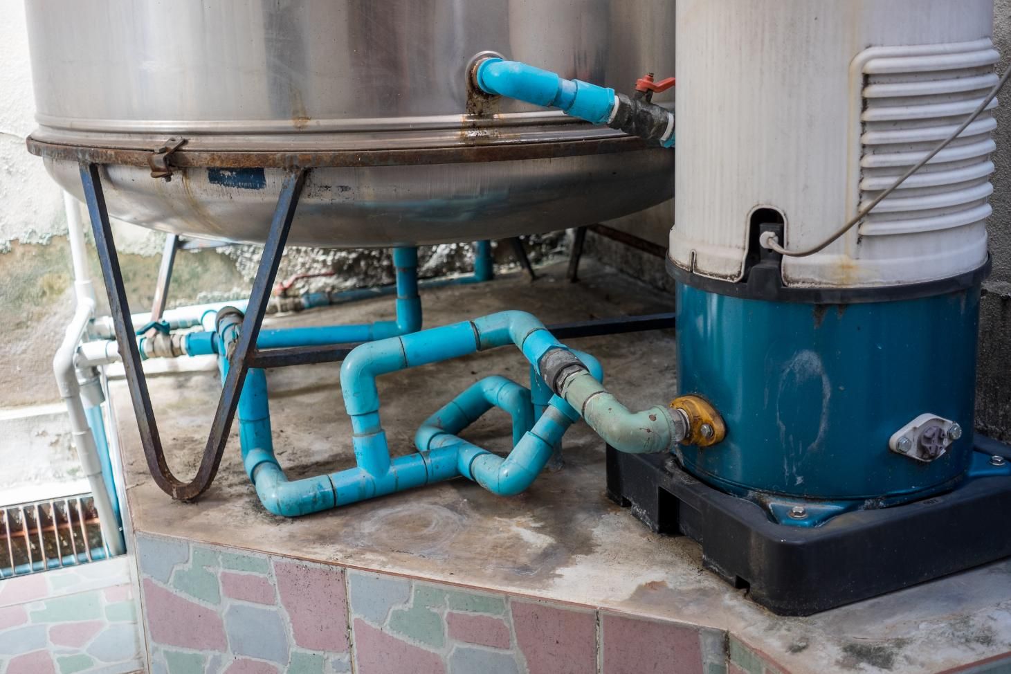 A Water Pump is Sitting Next to a Stainless Steel Tank — Edwards Plumbing Pty Ltd in South Murwillumbah, NSW