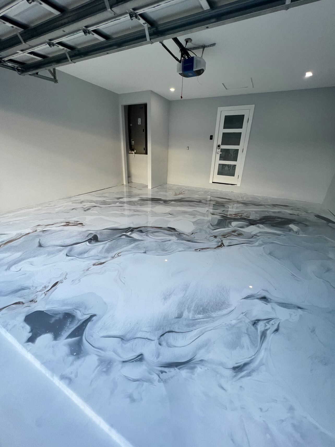 A garage with a marble floor and a door.