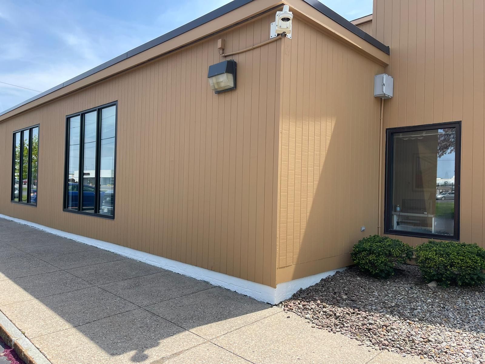 A brown building with a lot of windows and a camera on the side of it.