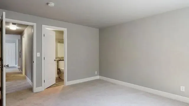 Bedroom with doorway to hallway and bathroom.