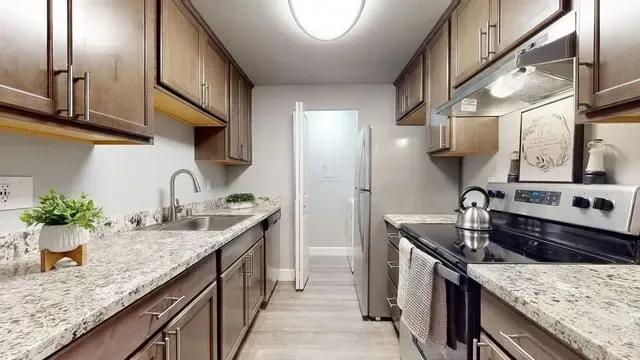 Kitchen with granite countertops, stainless steel appliances, and wood cabinets.
