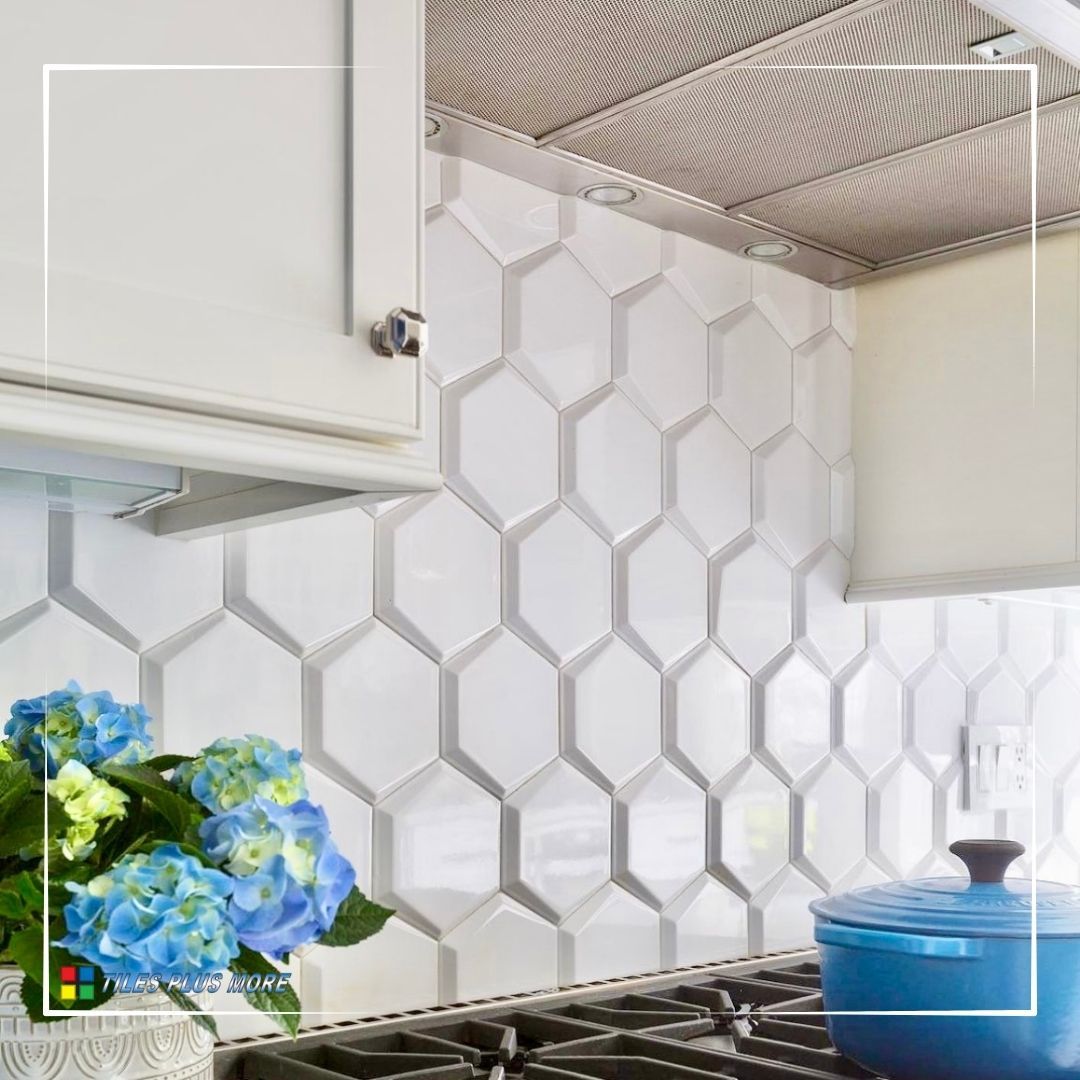 Modern kitchen with white hexagon tile backsplash, white cabinets, and a blue pot on the stove.