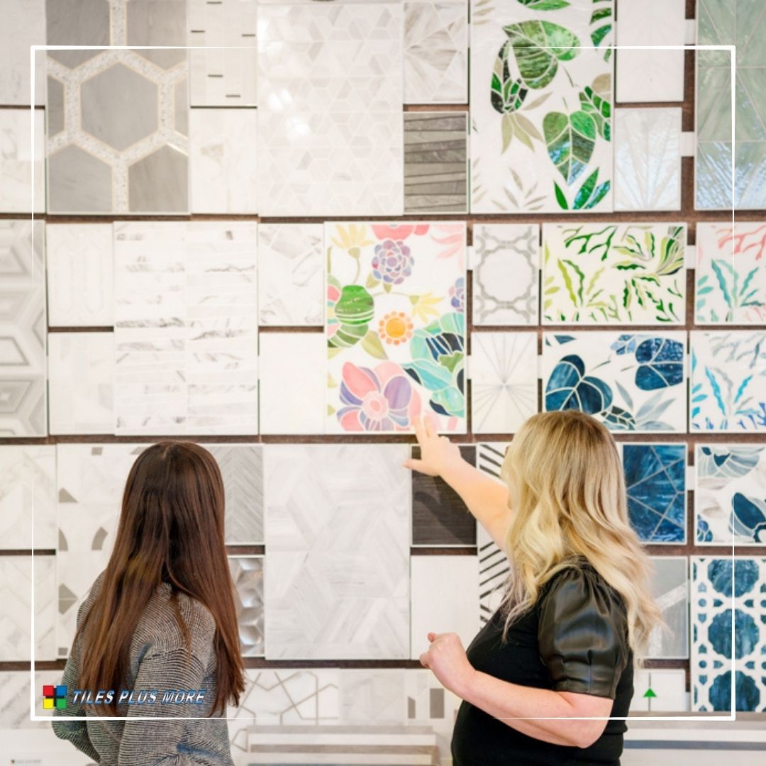 Two people in a tile showroom pointing at colorful wall tile samples