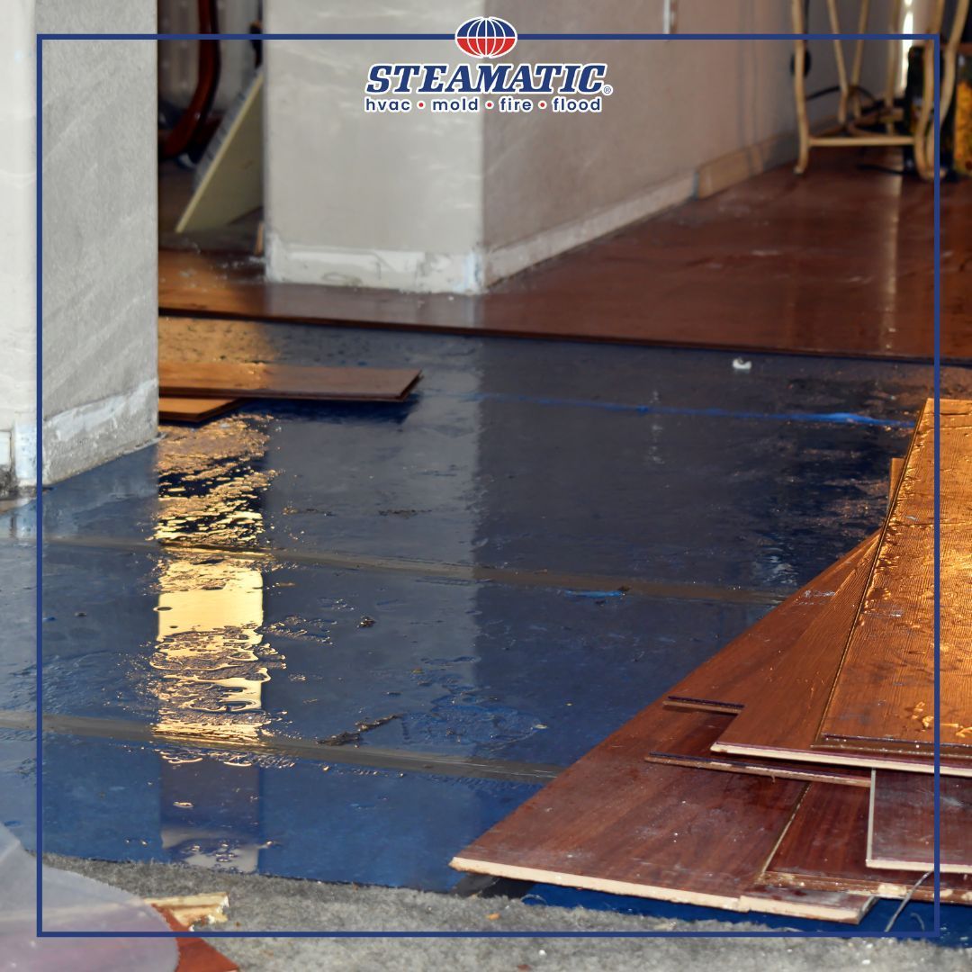 Blue epoxy floor in a room under repair, with wooden planks and a partially covered walkway