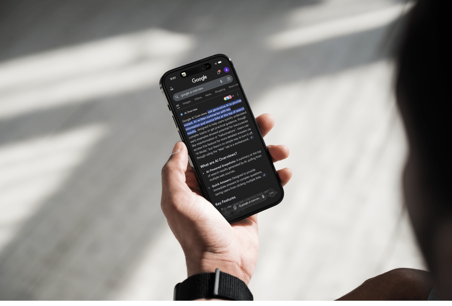 Person holding an iPhone viewing Google’s AI Overview search results.