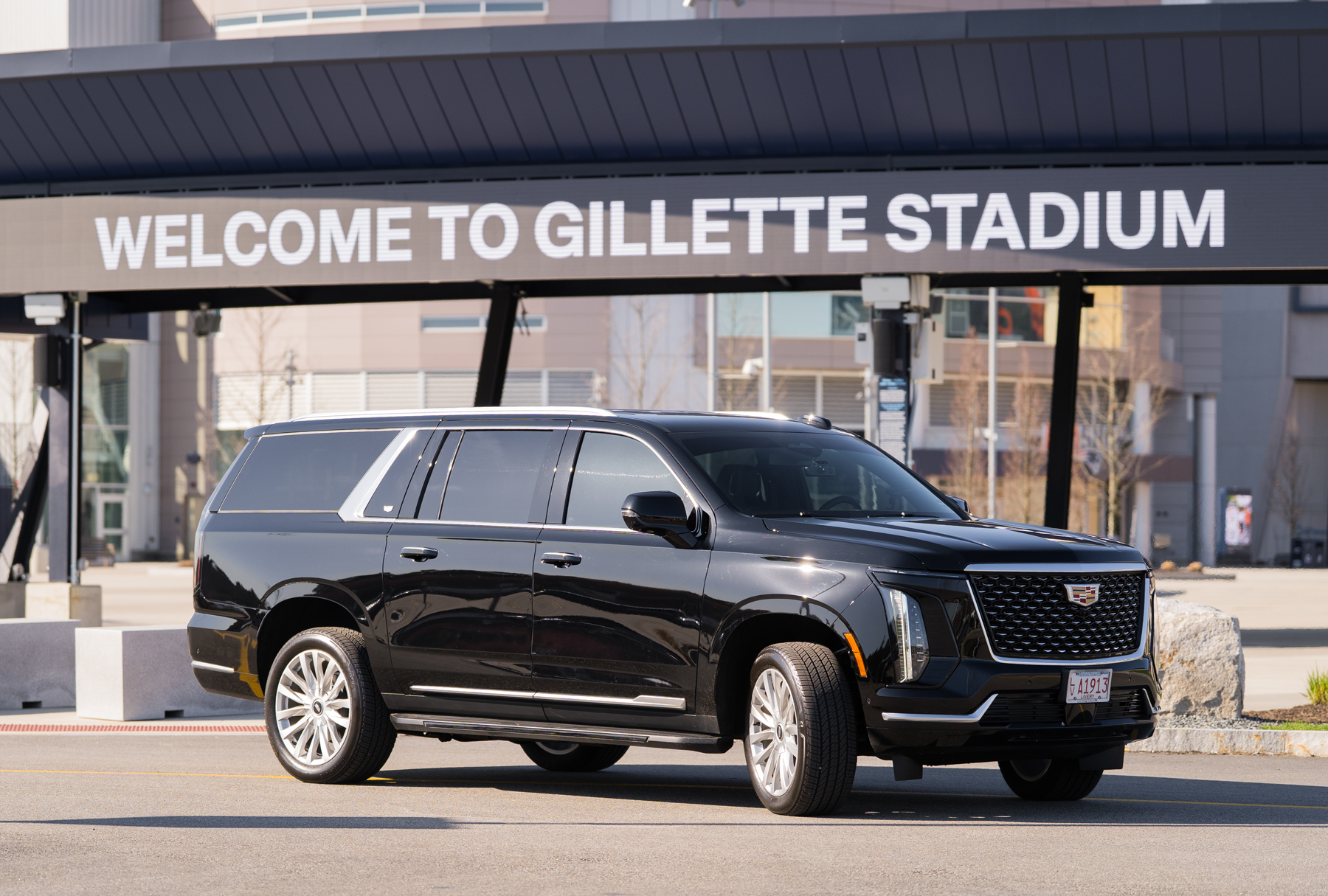Black SUV parked in front of the “Welcome to Gillette Stadium” entrance sign