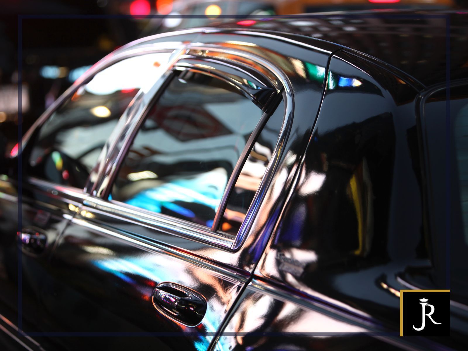 Glossy black car door with chrome trim and reflections