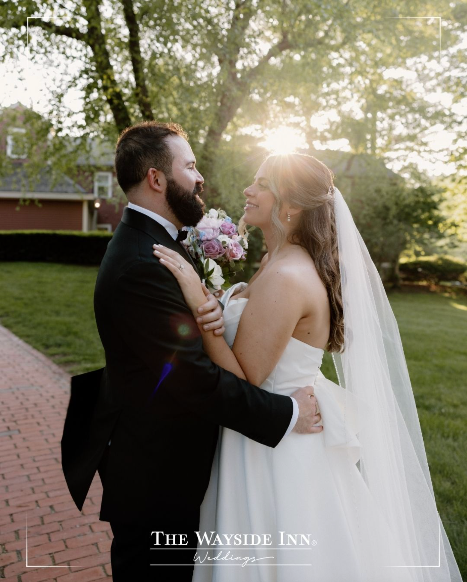 Bride and groom embracing outdoors in a sunlit garden at The Wayside Inn