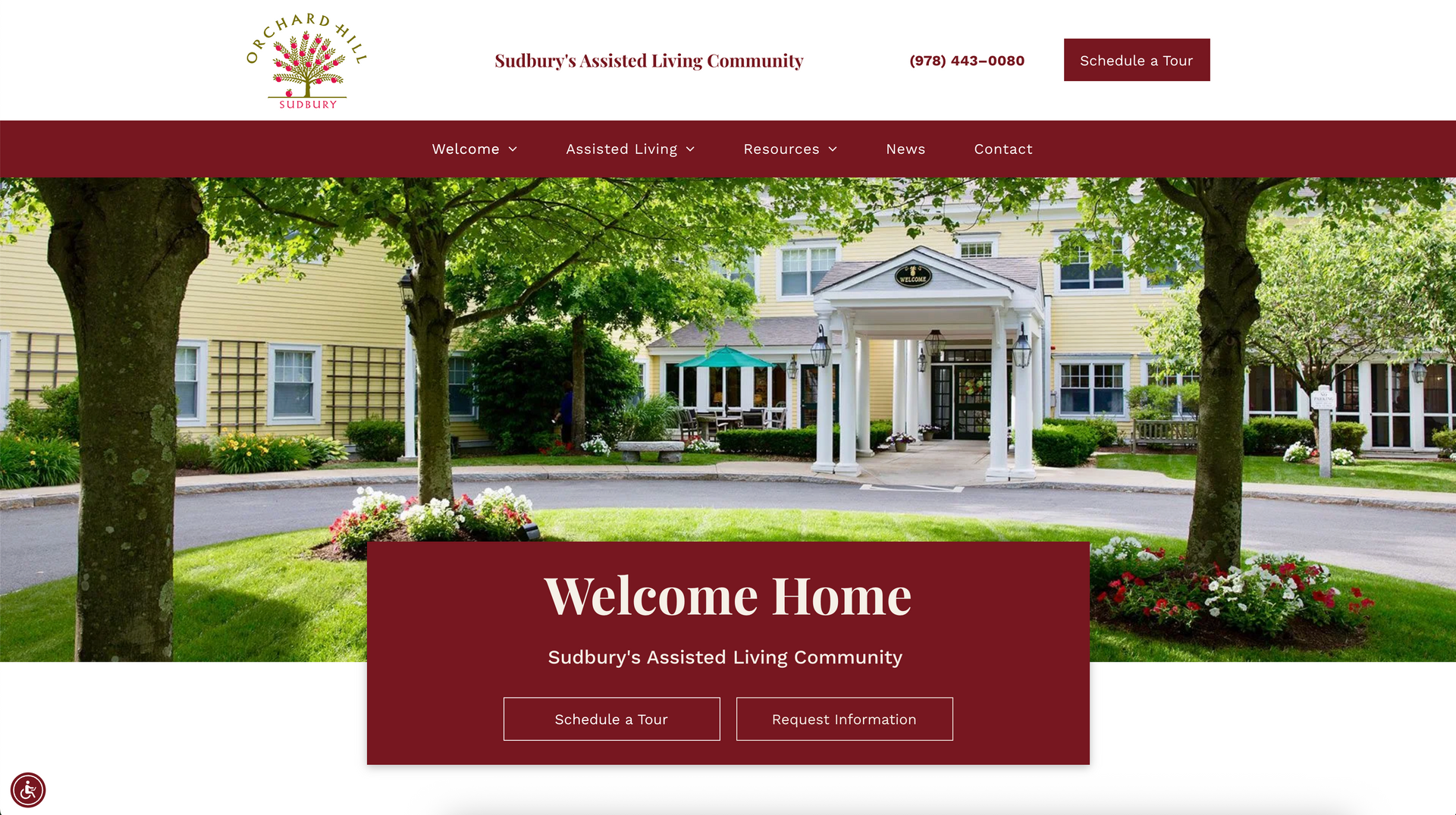 Homepage of a resort-style campus with a tree-lined driveway and maroon “Welcome Home” banner