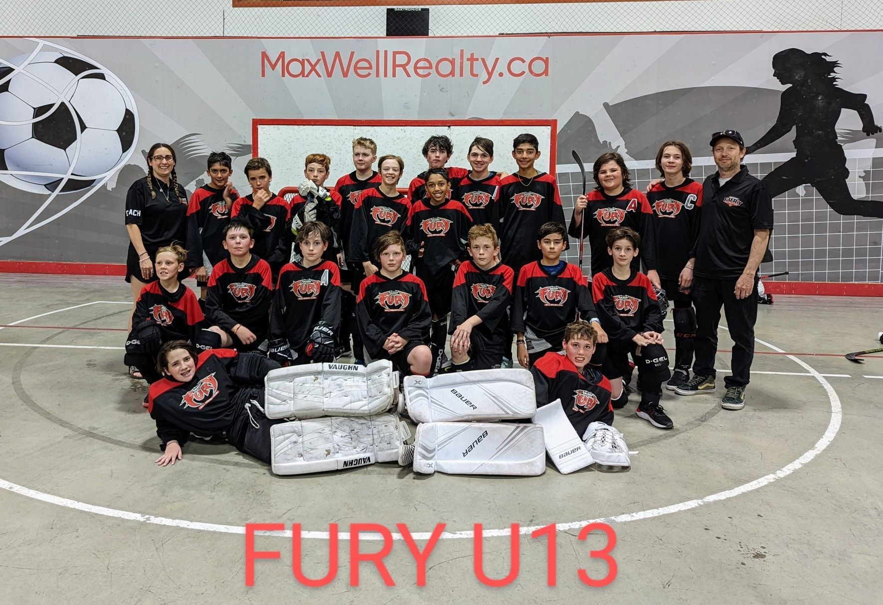 2022 U13 Fury ball hockey team group photo wearing black jerseys after a game