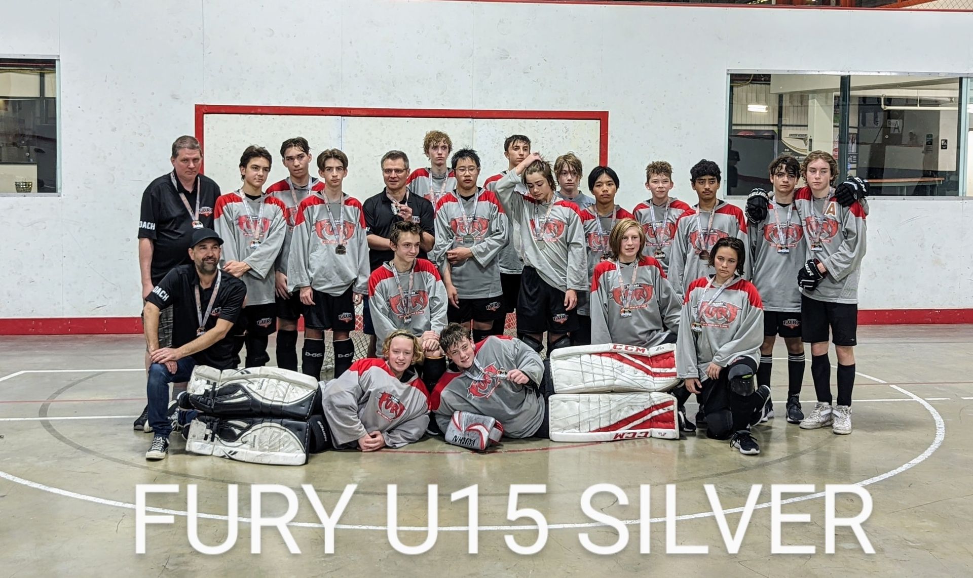 2022 U15 Fury ball hockey team group photo wearing grey jerseys after playing a game