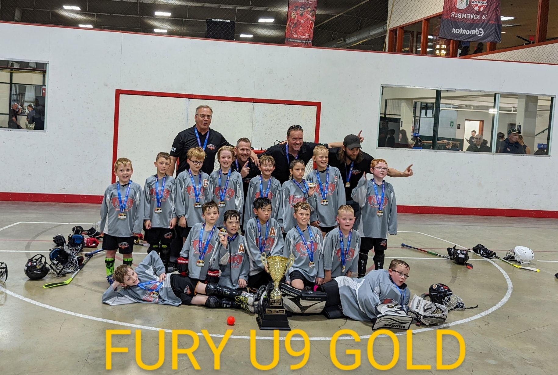 2022 U9 Fury ball hockey team group photo wearing grey jerseys after winning gold