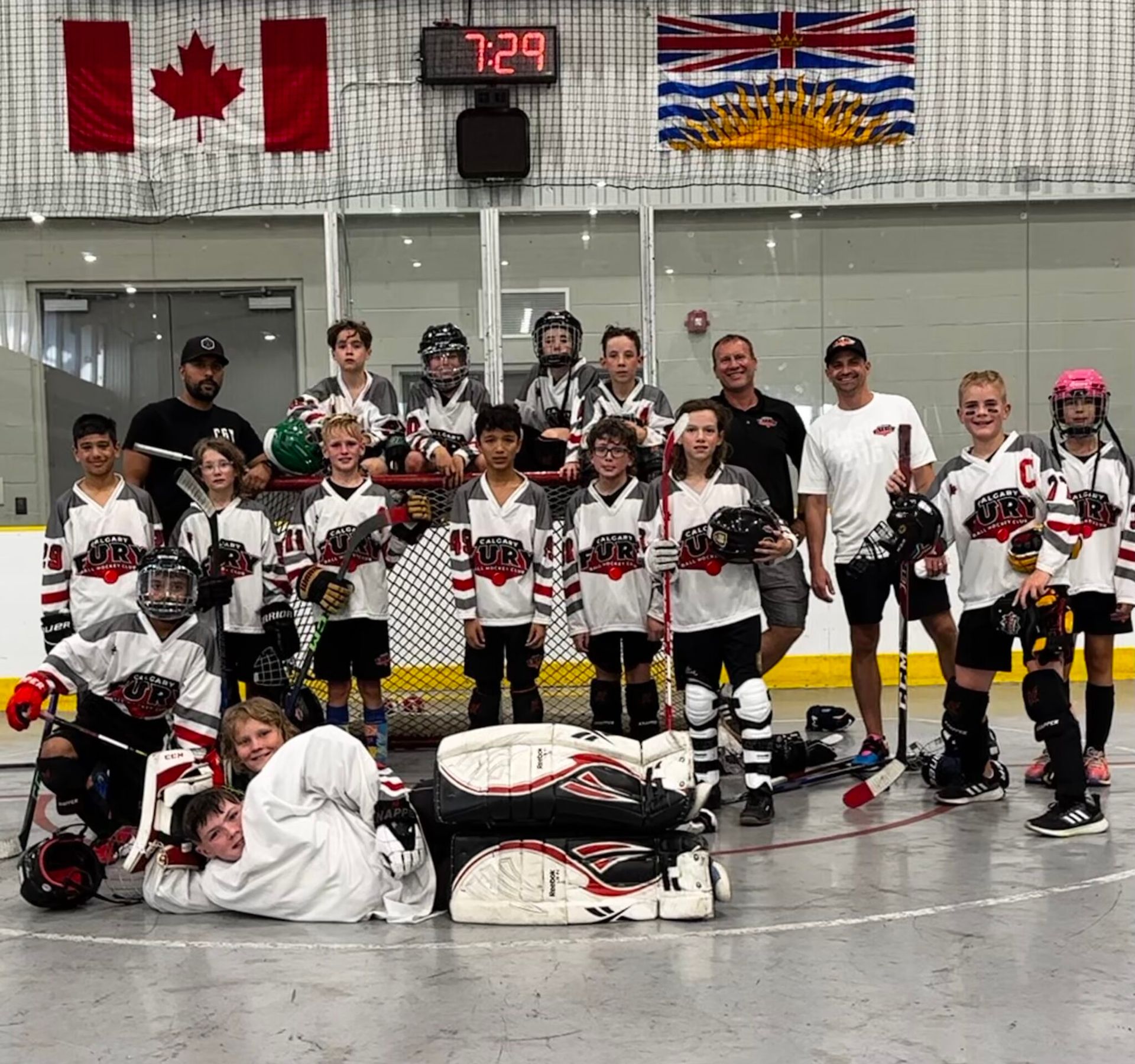 2024 U11 Fury ball hockey team group photo wearing white jerseys after playing a game