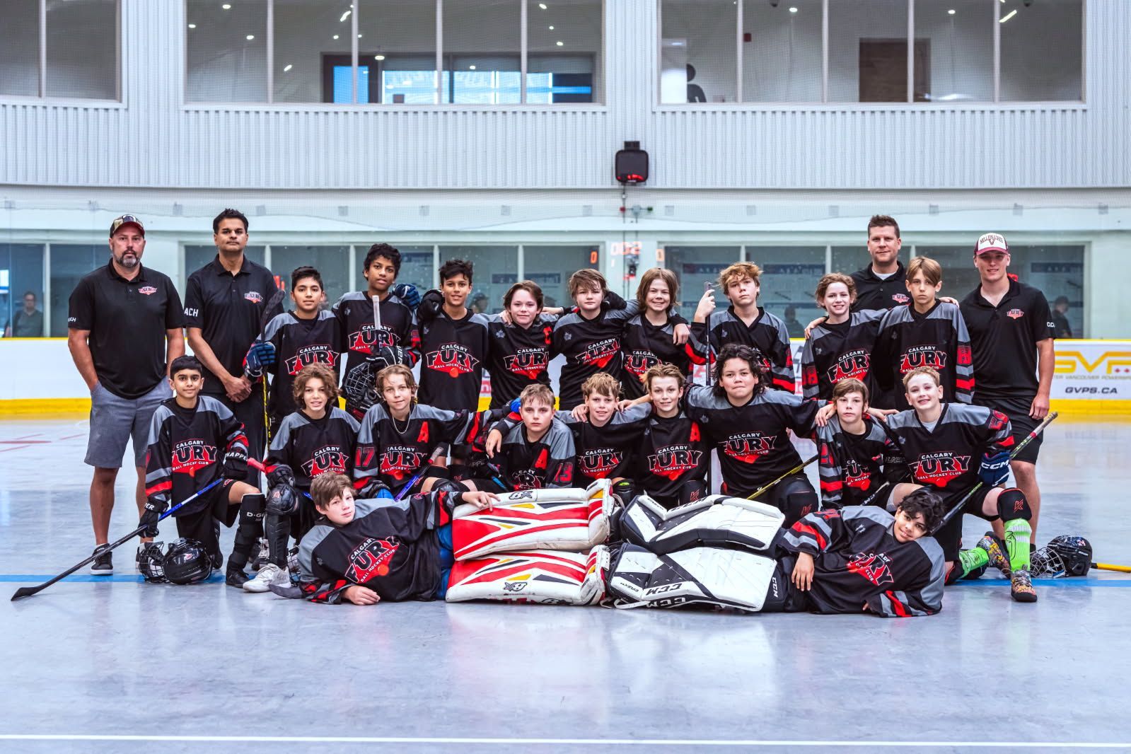 2024 U13 Fury ball hockey team group photo wearing black jerseys after a game