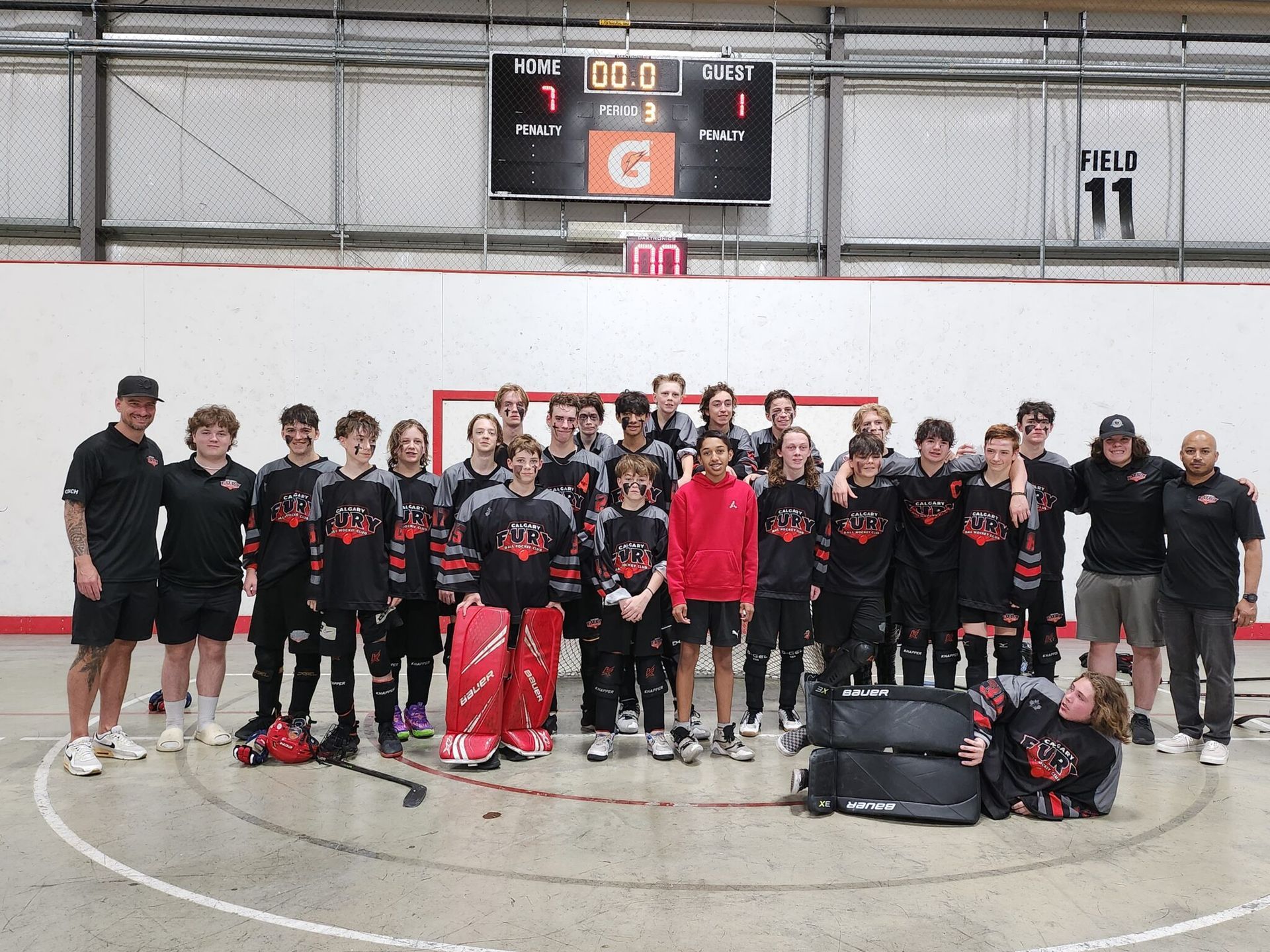 2024 U15 Fury ball hockey team group photo wearing black jersys after a game