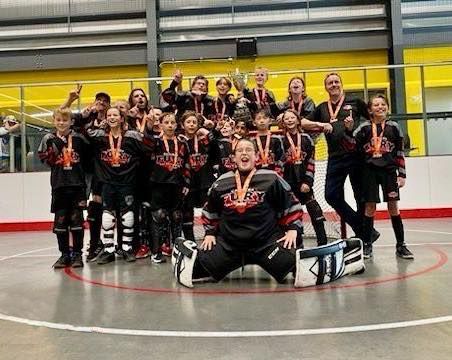 U11 Fury ball hockey team group photo wearing black jerseys after winning gold