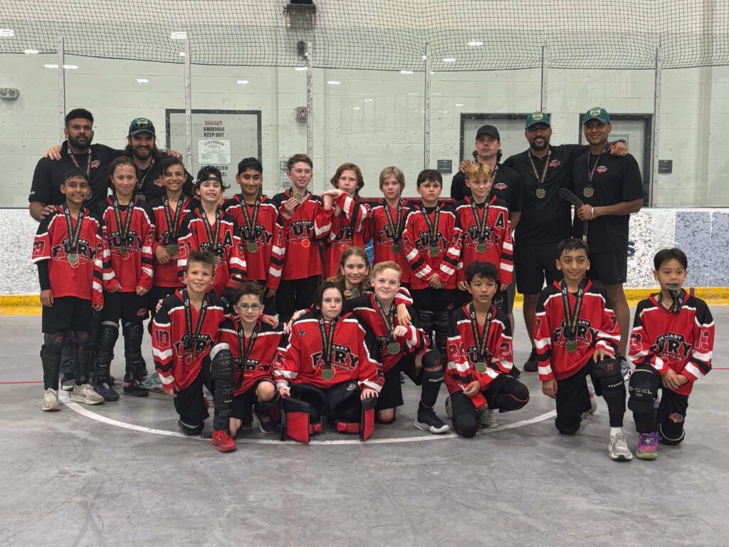 U11 Fury ball hockey team group photo wearing red jerseys after winning a medal
