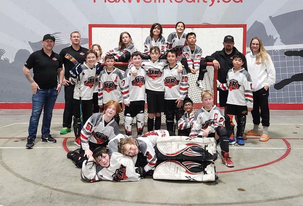2024 U11 Fury ball hockey team group photo wearing white jerseys after playing a game
