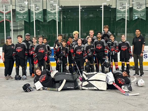U15 Fury ball hockey team group photo after a game wearing black jerseys