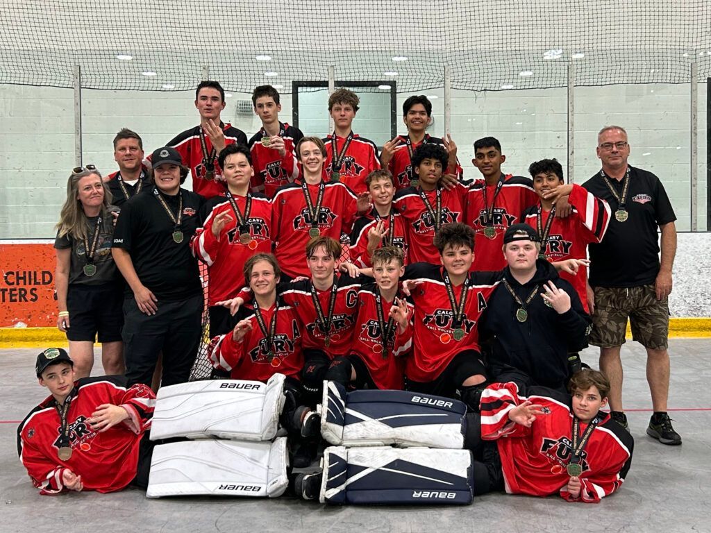 U15 Fury ball hockey team group photo wearing red jerseys after winning a medal