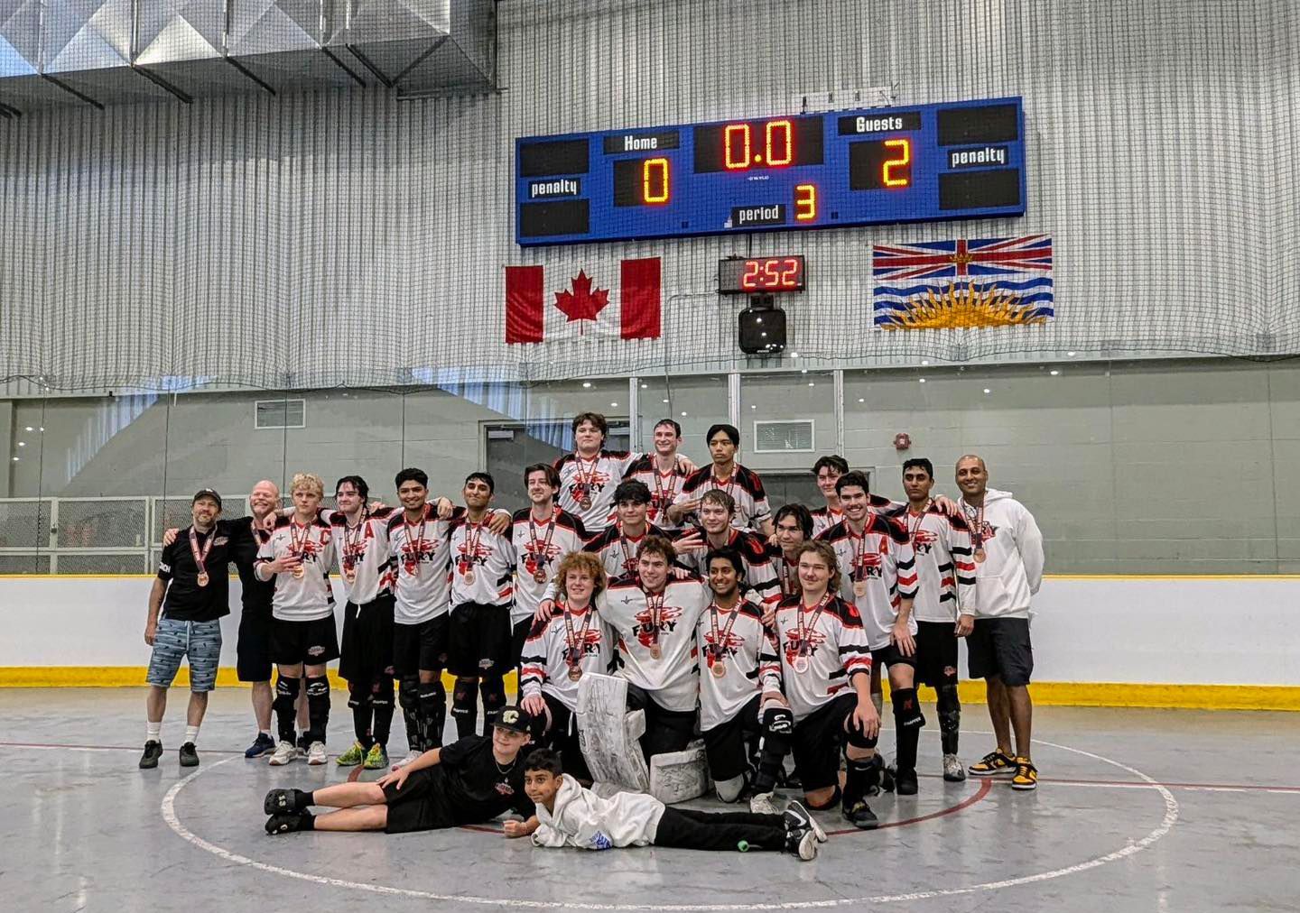 U19 Fury ball hockey team group photo wearing white jerseys after winning a medal at the Western Challenge Cup