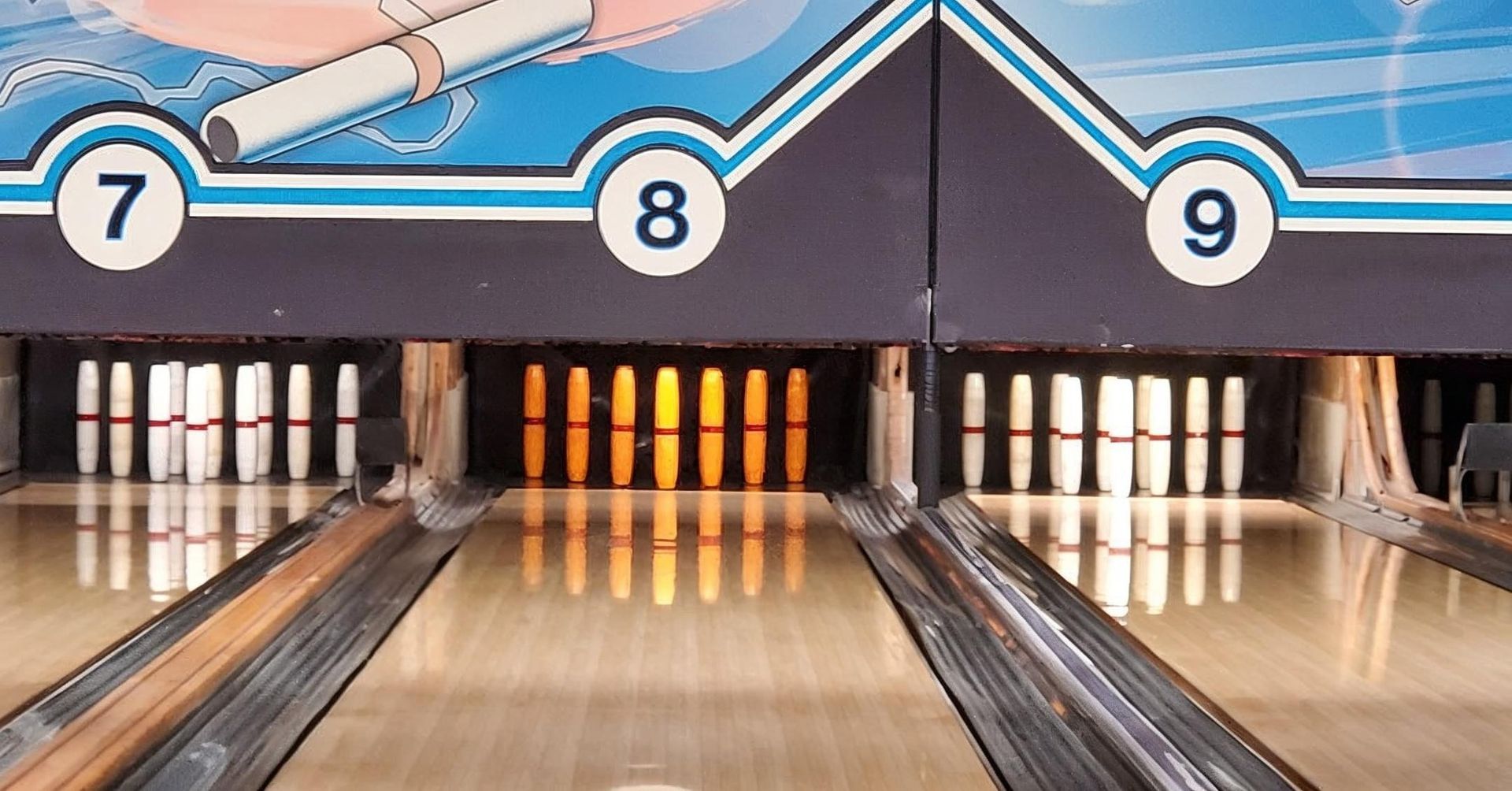 Bowling lane aiming at pins, with lane numbers 7, 8, and 9 overhead
