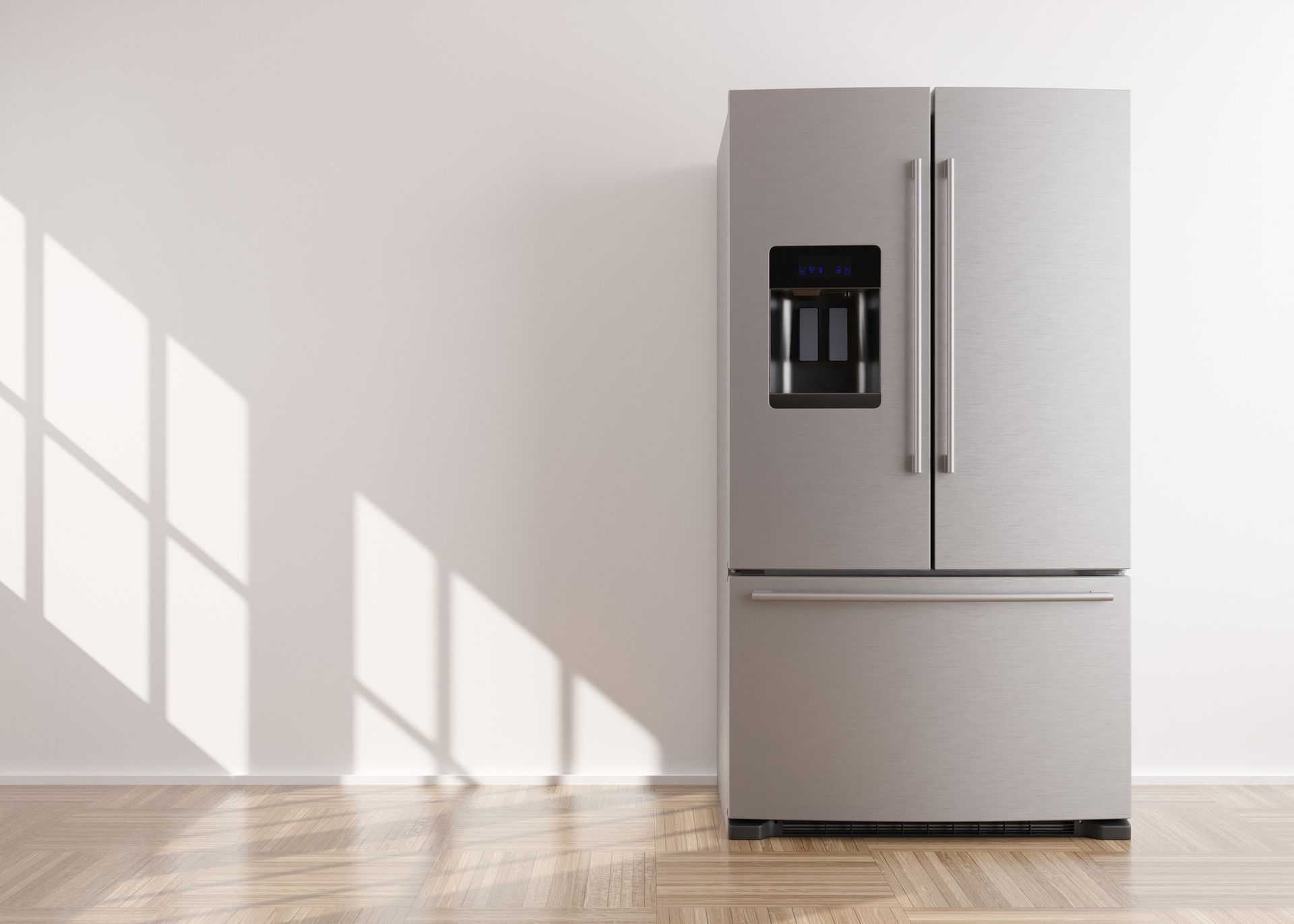 Stainless steel French door refrigerator against a white wall with sunlight.