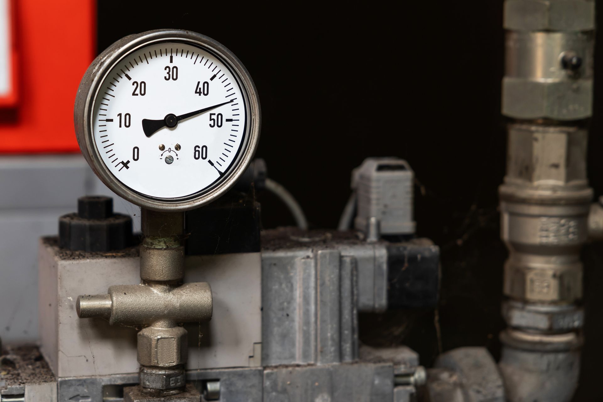 Pressure gauge reading approximately 40, mounted on industrial machinery with pipes and valves.