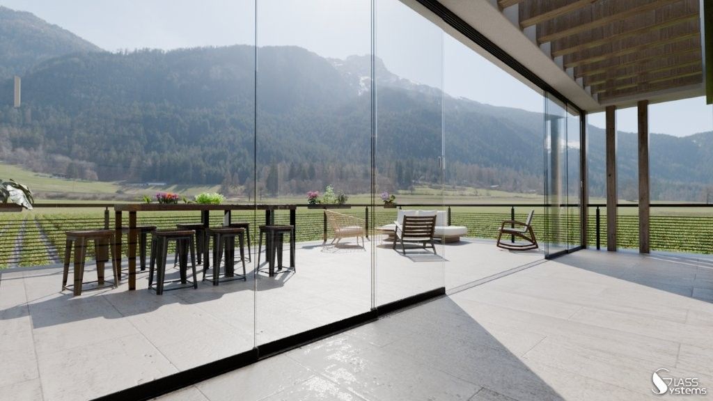 Terrasse moderne avec balustrade en verre, table et chaises en bois, donnant sur des montagnes verdoyantes et un lac