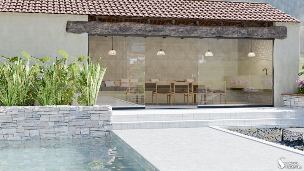Patio moderne avec portes coulissantes en verre, luminaires suspendus, chaises en bois et piscine devant un mur en pierre.