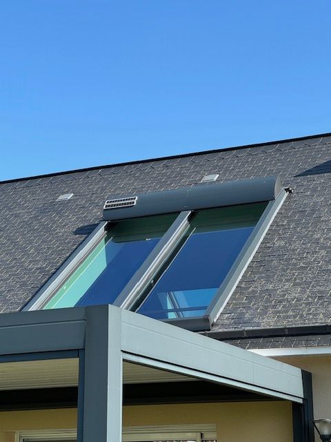 Toit de maison moderne avec fenêtres de toit sur fond de ciel bleu