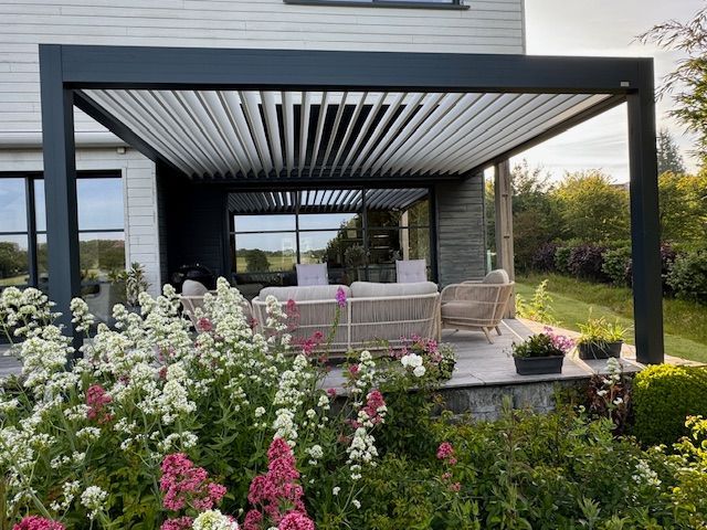 Pergola de patio moderne avec sièges d'extérieur, table et fleurs épanouies dans un cadre de jardin