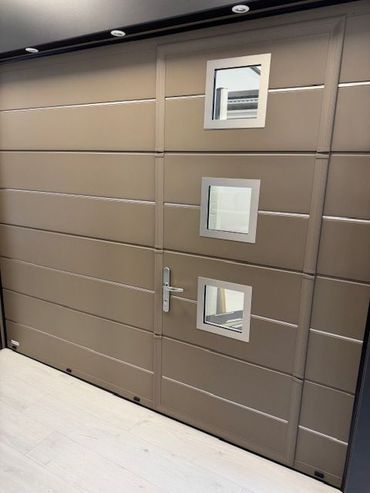 Mur marron moderne avec trois petites fenêtres carrées et une porte étroite dans un couloir