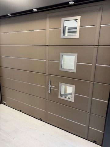 Mur marron moderne avec trois petites fenêtres carrées et une porte étroite dans un couloir