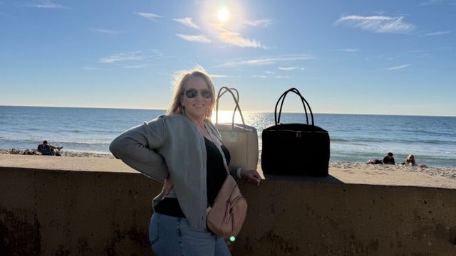 Woman carrying insulated tote bags by The Stever Co at Carlsbad boardwalk