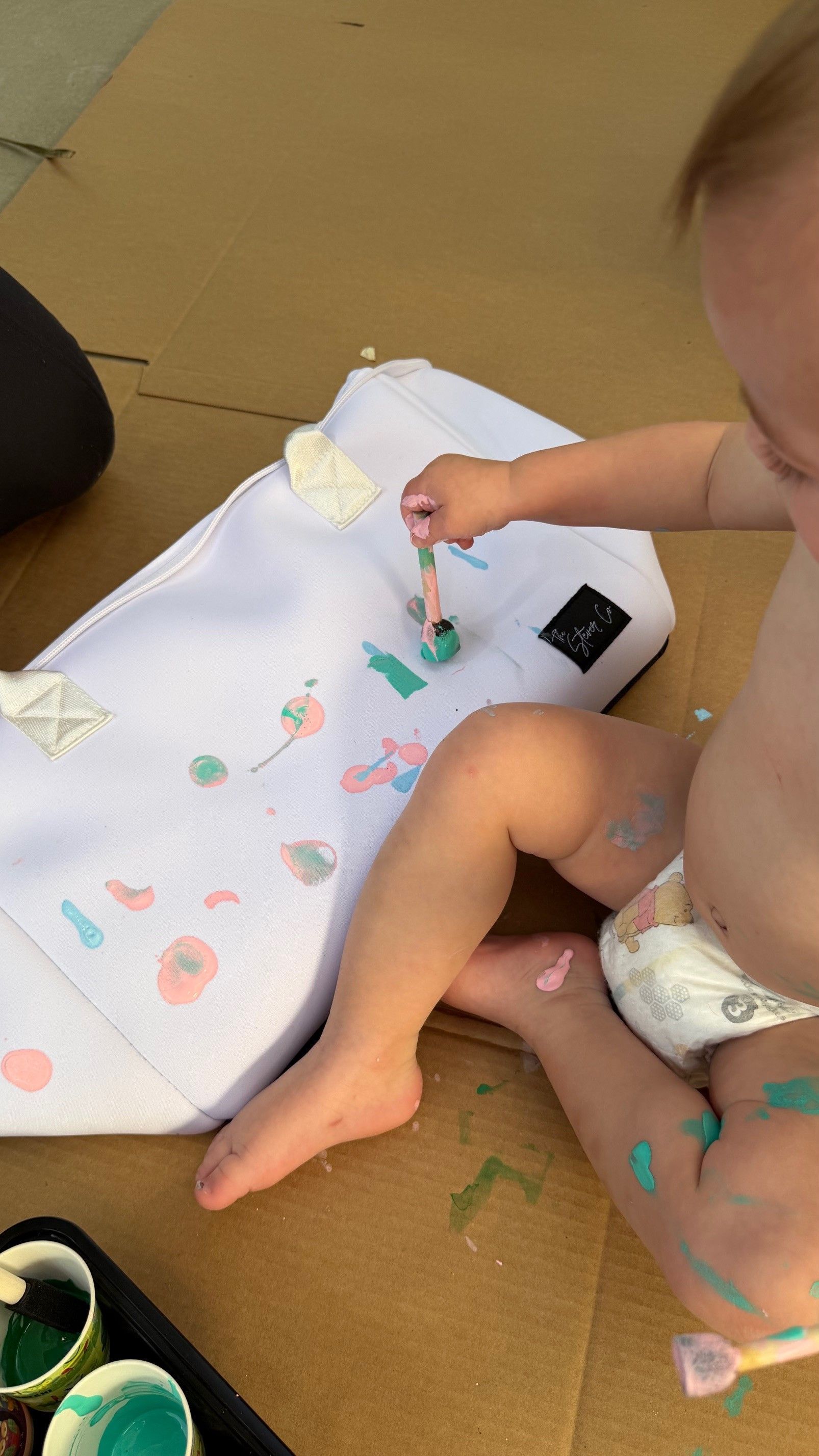 child painting The Stever Co Mom’s Favorite insulated tote with colorful paint for personalized handprint gift
