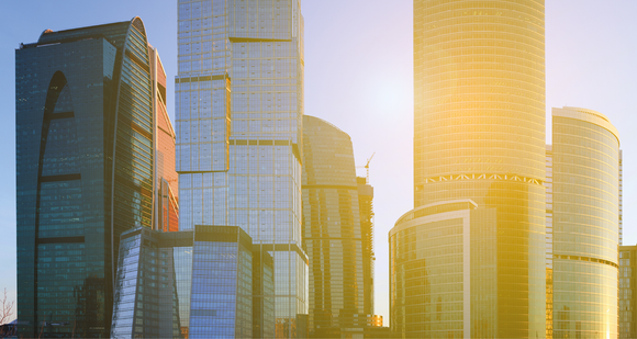 The sun is shining through the windows of a city skyline.