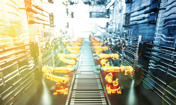 A conveyor belt in a factory with a lot of robots on it.